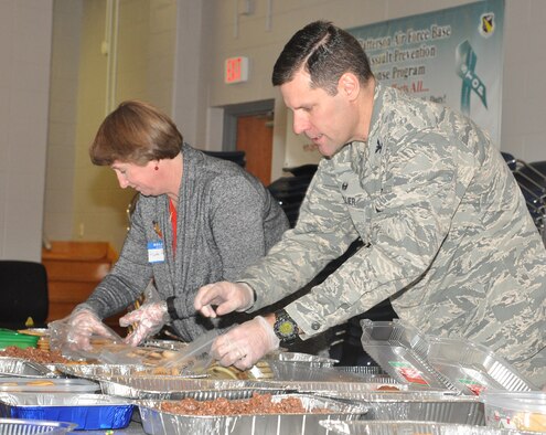 Col. John Devillier, 88th Air Base Wing commander, and Ruth Ann Thompson, wife of Lt. Gen. John Thompson, Air Force Life Cycle Management Center commander, package cookies and treats for the 15th annual Airmen's Holiday Cookie Drive Dec. 2 at the Community and Airman Center. (U.S. Air Force photo/Gina Marie Giardina)