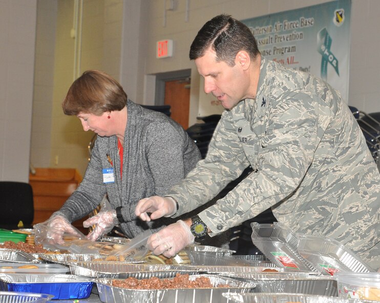 Col. John Devillier, 88th Air Base Wing commander, and Ruth Ann Thompson, wife of Lt. Gen. John Thompson, Air Force Life Cycle Management Center commander, package cookies and treats for the 15th annual Airmen's Holiday Cookie Drive Dec. 2 at the Community and Airman Center. (U.S. Air Force photo/Gina Marie Giardina)