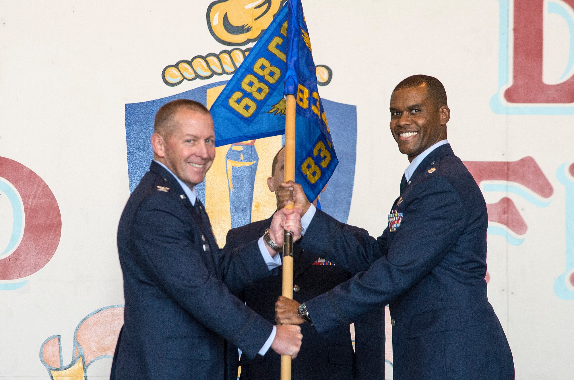 Col. Roger R. Vrooman, 688th Cyberspace Operations Group commander, passes the guidon to Lt Col. Theophilus D. Jackman as he assumes command of the 834th Cyberspace Operations Squadron Dec. 3 at Joint Base San Antonio-Lackland. (U.S. Air Force photo by Johnny Saldivar)

