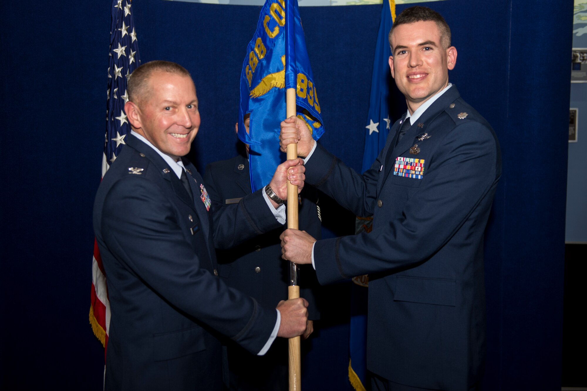 Col. Roger Vrooman, 688th Cyberspace Operations Group commander, passes the guidon to Lt. Col. David Chaboya during the 835th Cyberspace Operations Squadron activation ceremony Dec. 1 at Scott Air Force Base, Ill. Chaboya will lead the 835th  responsible for defensive cyberspace operations supporting Air Force and DOD missions. (U.S. Air Force Photo/Senior Airman Jake Eckhardt)
