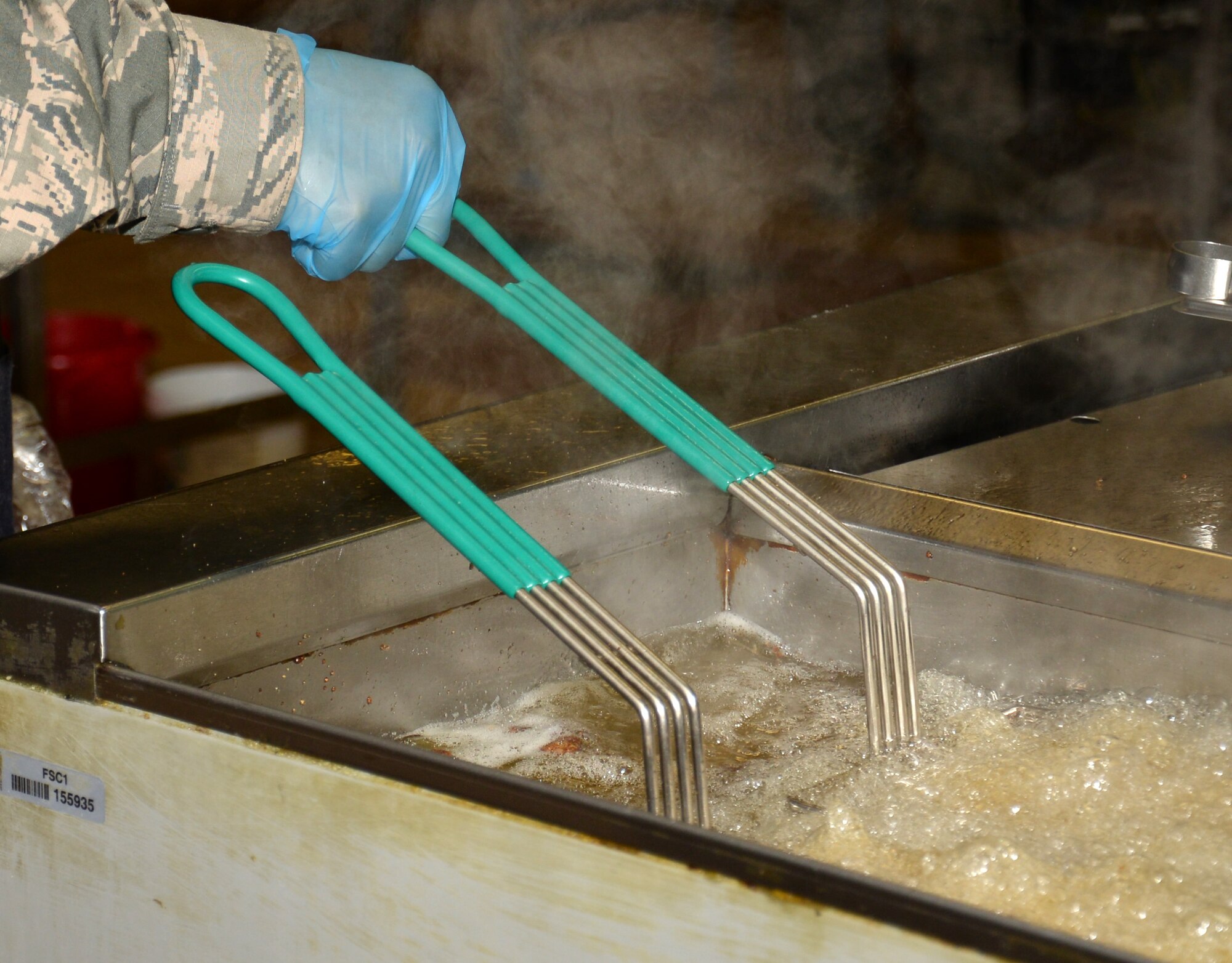 U.S. Air Force Staff Sgt. Christopher Williams, 100th Force Support Squadron Gateway Dining Facility shift supervisor, prepares food to be served during lunch Nov. 23, 2015, on RAF Mildenhall, England. The military members who work at the facility are also rotated to the fitness centers, lodging, and readiness to expand their skills in the services career field. (U.S. Air Force photo by Gina Randall/Released)