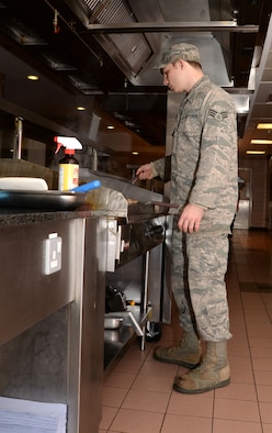 U.S. Air Force Senior Airman Jacob Phelps, 100th Force Support Squadron Gateway Dining Facility food service journeyman, prepares food to serve to customers Nov. 23, 2015, on RAF Mildenhall, England. The facility is made up of military members and civilians serving meals to the base population. (U.S. Air Force photo by Gina Randall/Released)