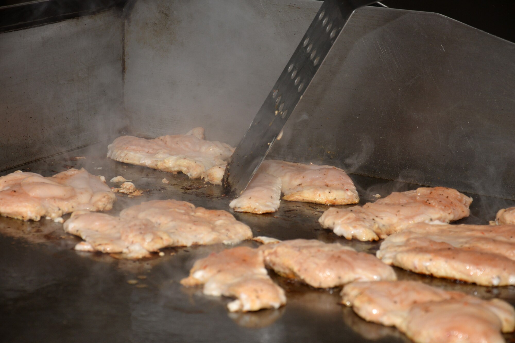 Chicken is grilled in preparation for lunch at the 100th Force Support Squadron’s Gateway Dining Facility Nov. 23, 2015, on RAF Mildenhall, England. The facility staff cooks meals including healthy options to serve patrons members. (U.S. Air Force photo by Gina Randall/Released)
