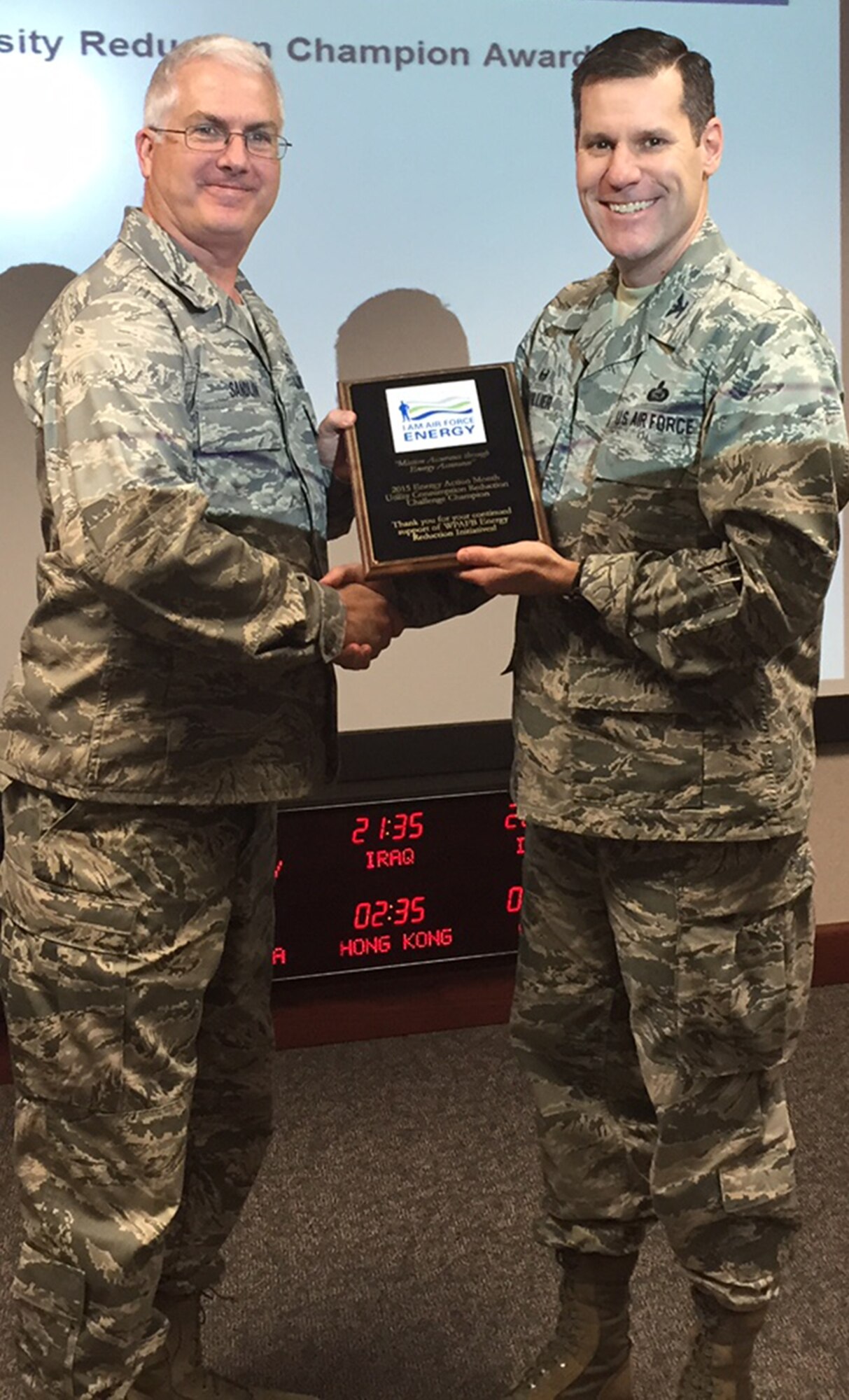 2015 EAM Energy Intensity Reduction Champion Award to Col. Doral Ned Sandlin, Air Force Institute of Technology commandant, at the Nov. 18 meeting of the 88 ABW Energy Management Steering Group. AFIT was one of 10 mission partners to take part in the competition as part of Energy Action Month in October. AFIT had the greatest percentage of 'intensity reduction' in Bld. 641, Area B. (Skywrighter photo/Amy Rollins)