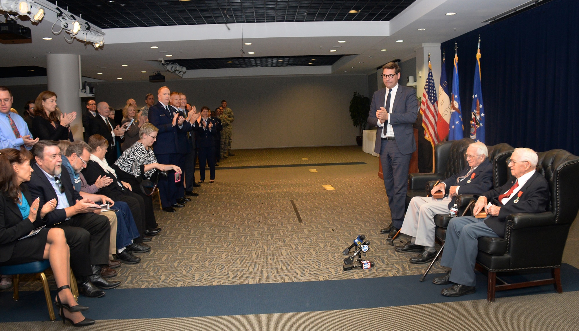 Christophe Lemoine, French consul general in Los Angeles, joins an audience of family and friends at the Gordon Conference Center in the Schriever Space Complex of the Space and Missile Systems Center in congratulating identical twin brothers and retired Air Force Reserve Majs. Russell “Lynn” Clanin and Raymond “Glenn” Clanin as the newest recipients of the French government's highest distinction for their military service as World War II veterans, the Legion of Honor medal. (U.S. Air Force photo/Van De Ha)