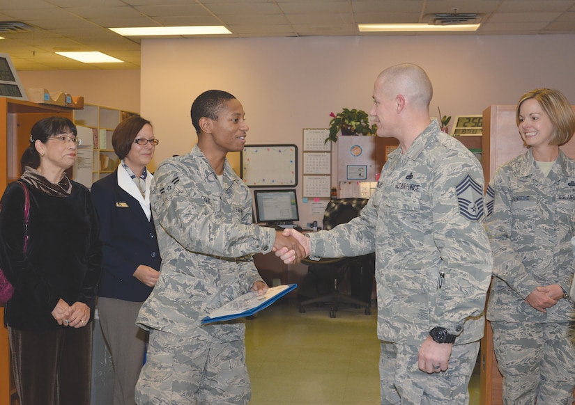 Airman 1st Class Tyrice Davis, third from left, of the 377th Medical Support Squadron receives congratulations from Chief Master Sgt. Ronnie Phillips, vice president of the Kirtland Chiefs’ Group, after the group presented him with the Sharp Troop award. (Photo by Jamie Burnett)