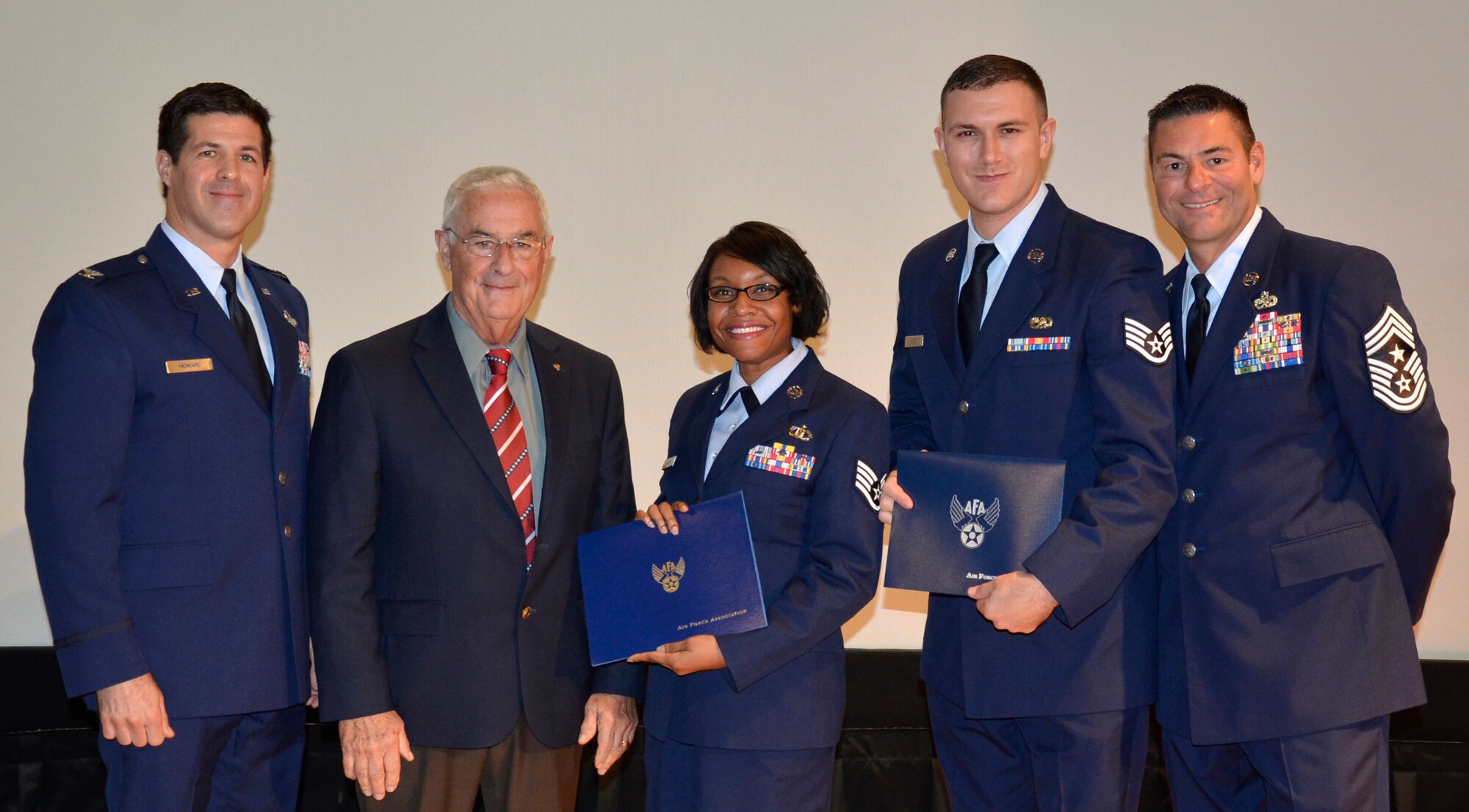 During a 920th Rescue Wing Community College of the Air Force graduation ceremony Dec. 5 at the Patrick Air Force Base Theater, two of the 43 wing airmen who graduated were presented with the William H. Pitsenbarger Award for pursuing even higher education to obtain Bachelor ’s degrees. Each award recipient received a certificate and a $400 check from the Air Force Association. From left to right are: Col. Paul Brett Howard, 920th Vice Wing Commander; Chief Master Sgt. Chris Bailey, Retired, President of the local Air Force Association Chapter; Staff Sgt. Tracy Parks, 920th Force Support Squadron; Staff Sgt. Jason, Coker, 920th Aircraft Maintenance Squadron and Command Chief Tim Bianchi, 920th Rescue Wing. (U.S. Air Force photo/2nd Lt. Annamarie Wyant)