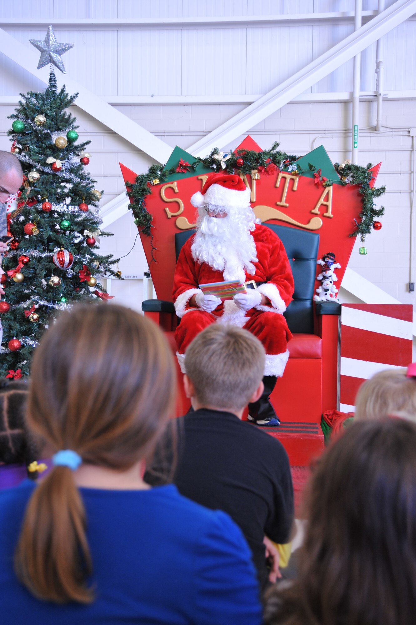 Children of 403rd Wing members visited with Santa Claus, who handed out presents, during the Wing’s Holiday Party in the isochronal dock Dec. 5, 2015.  An inflatable slide, obstacle course, and jump house were available for the children to play on during the party.    (U.S. Air Force photo by Master Sgt. Jessica Kendziorek)