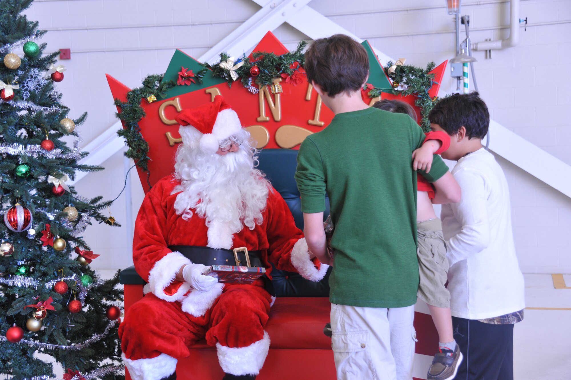 Children of 403rd Wing members received gifts from Santa Claus, during the Wing’s Holiday Party in the isochronal dock Dec. 5, 2015.  An inflatable slide, obstacle course, and jump house were available for the children to play on during the party.    (U.S. Air Force photo by Master Sgt. Jessica Kendziorek)
