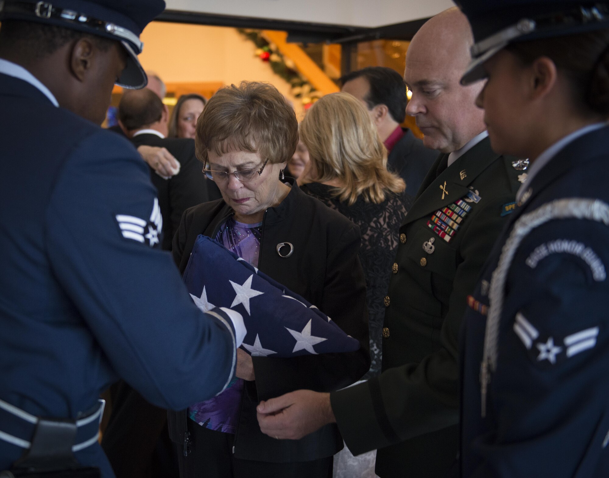 The Eglin Air Force Base Honor Guard presents the empty bullet shells to Judy Haugen, the widow of retired Brig. Gen. Donald Haugen, during a memorial ceremony for retired Reserve Brig. Gen. Donald Haugen Dec. 5 at Crosspoint Methodist Church in Niceville, Fla.  The 84-year-old Haugen, who passed away Dec. 1, was the first commander of a 919th designated unit assigned to Duke Field, the 919th Tactical Airlift Group.  The designation still resides there today with the special operations Reserve unit, 919th Special Operations Wing, still resides there today.  Many of the tactical airlift capabilities that began under his leadership are still part of the current 919th SOW mission.  (U.S. Air Force photo/Tech. Sgt. Jasmin Taylor)