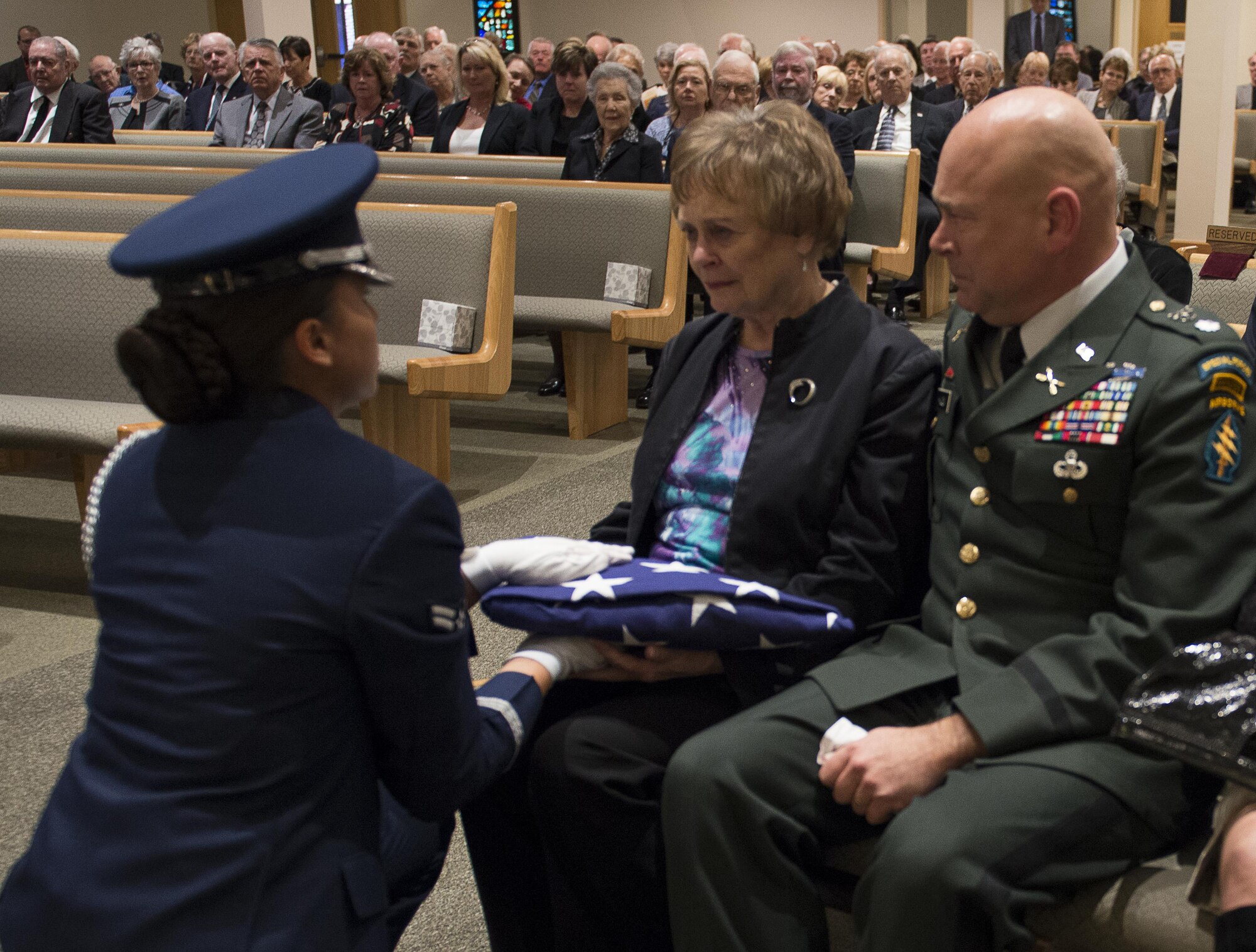 A member of the Eglin Air Force Base Honor Guard presents a folded American flag to Judy Haugen, the widow of retired Brig. Gen. Donald Haugen, during a memorial ceremony Dec. 5 at Crosspoint Methodist Church in Niceville, Fla.  The 84-year-old Haugen, who passed away Dec. 1, was the first commander of a 919th designated unit assigned to Duke Field, the 919th Tactical Airlift Group.  The designation still resides there today with the special operations Reserve unit, 919th Special Operations Wing, still resides there today.  Many of the tactical airlift capabilities that began under his leadership are still part of the current 919th SOW mission.  (U.S. Air Force photo/Tech. Sgt. Jasmin Taylor)