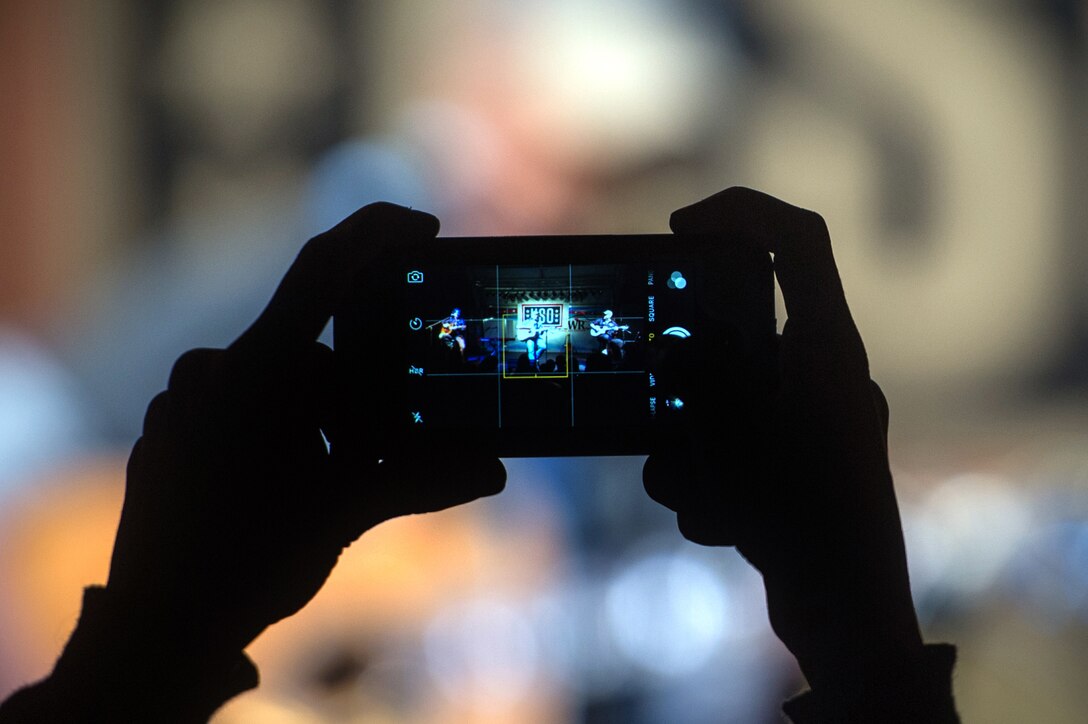 A U.S. service member takes a photo during a USO show on Naval Air Station Sigonella, Italy, Dec. 5, 2015. DoD photo by D. Myles Cullen/Released