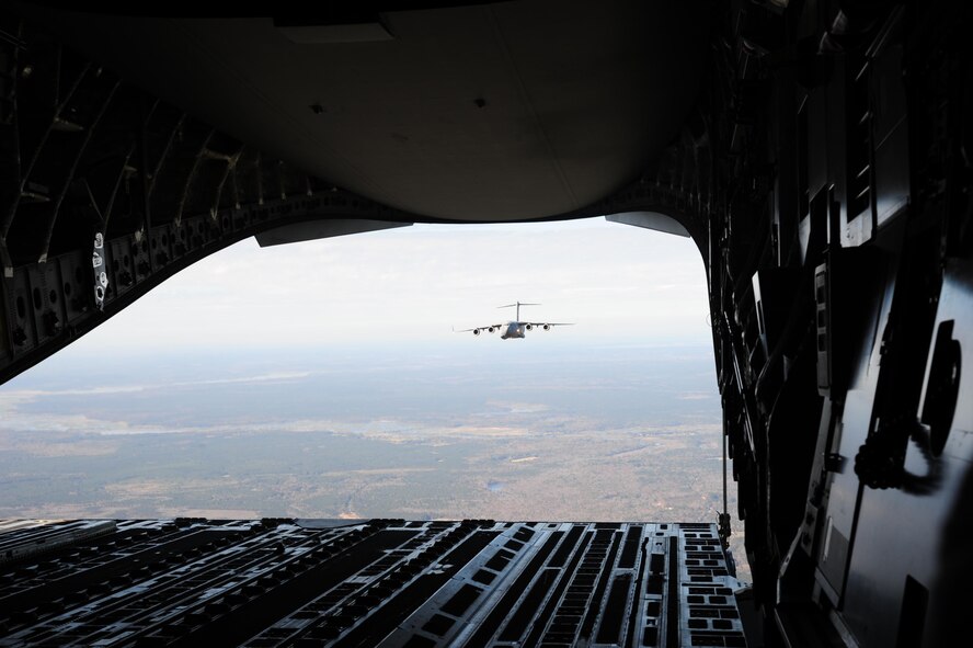 A C-17 Globemaster III aircraft from Joint Base Charleston, SC flies in formation as spouses from the 315th Airlift Wing here enjoy the view during a spouse flight Saturday, Dec. 5. Spouse flights are an opportunity for spouses of Airmen to experience a peek behind the curtain of what their loved ones do during their monthly unit training assembly weekends and annual tour committment. (U.S. Air Force photo by Staff Sgt. Bobby Pilch)