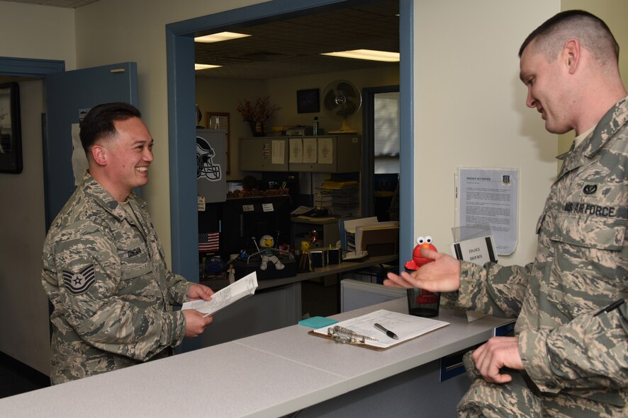 Tech. Sgt. Dingman assists an Airman with a smile at the 911th Airlift Wing finance office at the Pittsburgh International Airport Air Reserve Station, Nov. 8, 2015. Dingman, a 13-year member of the 911th AW, said that his favorite part of his job was helping people. (U.S. Air Force photo by Senior Airman Marjorie A. Bowlden)