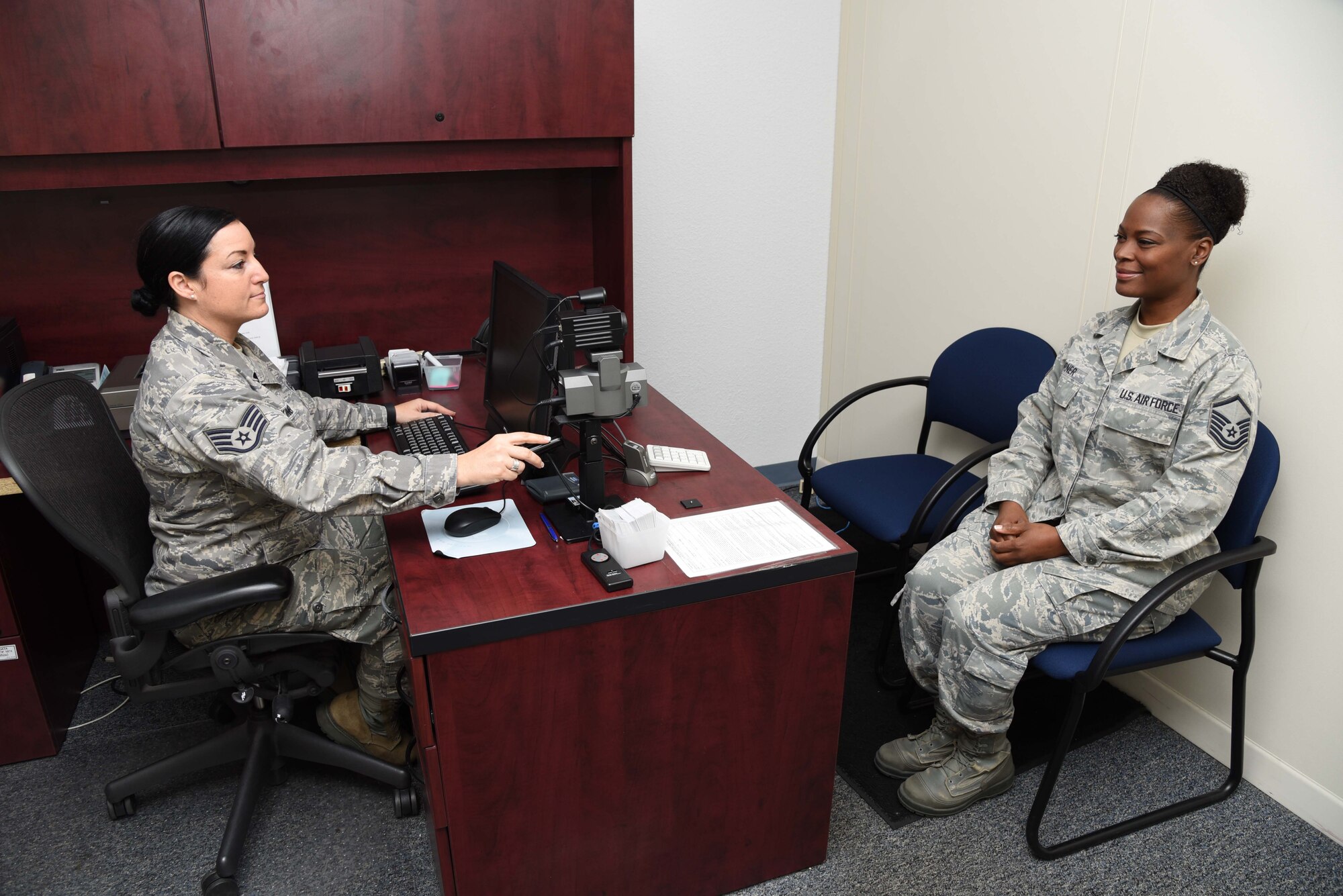 Staff Sgt. Tiffany Skinner, 403rd Force Support Squadron non commissioned officer in charge, takes a military ID picture for Master Sgt. Michelle Turner, 403rd FSS chief of customer support, Dec. 6, 2015, at the Sablich Center at Keesler Air Force Base, Mississippi. The reserve 403rd FSS and active-duty 81st FSS is scheduled to integrate their functions to assist each other in serving the needs of both active-duty and reserve personnel, retirees, and their families, streamlining customer service to make it more cost-effective and customer focused. (U.S. Air Force photo/Tech. Sgt. Ryan Labadens)
