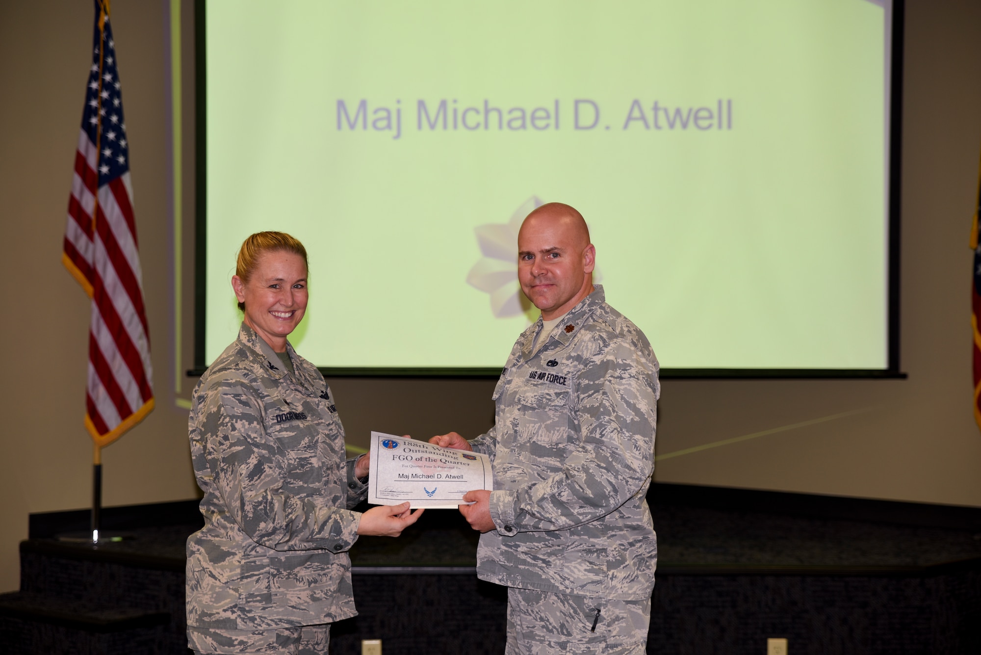 Maj. Michael Atwell is presented the certificate for his selection as the Field Grade Officer of the Quarter by Col. Bobbi Doorenbos, 188th Wing Commander, during a commander's call held Dec. 5, 2015. Nineteen Airmen of the Quarter nominees were recognized for their exceptional service to the wing during the last quarter that distinguished themselves among their peers in the 188th. Winners were selected in the Airman, Noncommissioned Officer, Senior NCO, Company Grade Officer and Field Grade Officer categories. (U.S. Air National Guard photo by Capt. Holli Nelson/released)