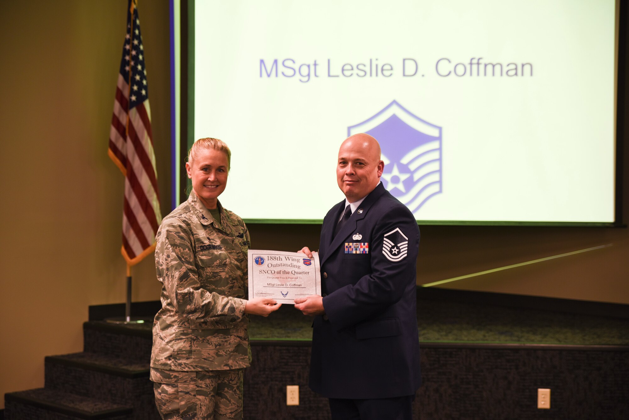 Master Sgt. Leslie Coffman is presented the certificate for his selection as the Senior Noncommissioned Officer of the Quarter by Col. Bobbi Doorenbos, 188th Wing Commander, during a commander's call held Dec. 5, 2015. Nineteen Airmen of the Quarter nominees were recognized for their exceptional service to the wing during the last quarter that distinguished themselves among their peers in the 188th. Winners were selected in the Airman, Noncommissioned Officer, Senior NCO, Company Grade Officer and Field Grade Officer categories. (U.S. Air National Guard photo by Capt. Holli Nelson/released)
