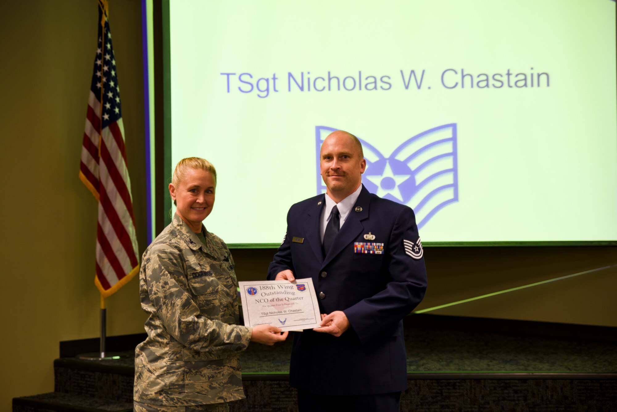 Tech. Sgt. Nicholas Chastain is presented the certificate for his selection as the Noncommissioned Officer of the Quarter by Col. Bobbi Doorenbos, 188th Wing Commander, during a commander's call held Dec. 5, 2015. Nineteen Airmen of the Quarter nominees were recognized for their exceptional service to the wing during the last quarter that distinguished themselves among their peers in the 188th. Winners were selected in the Airman, Noncommissioned Officer, Senior NCO, Company Grade Officer and Field Grade Officer categories. (U.S. Air National Guard photo by Capt. Holli Nelson/released)   