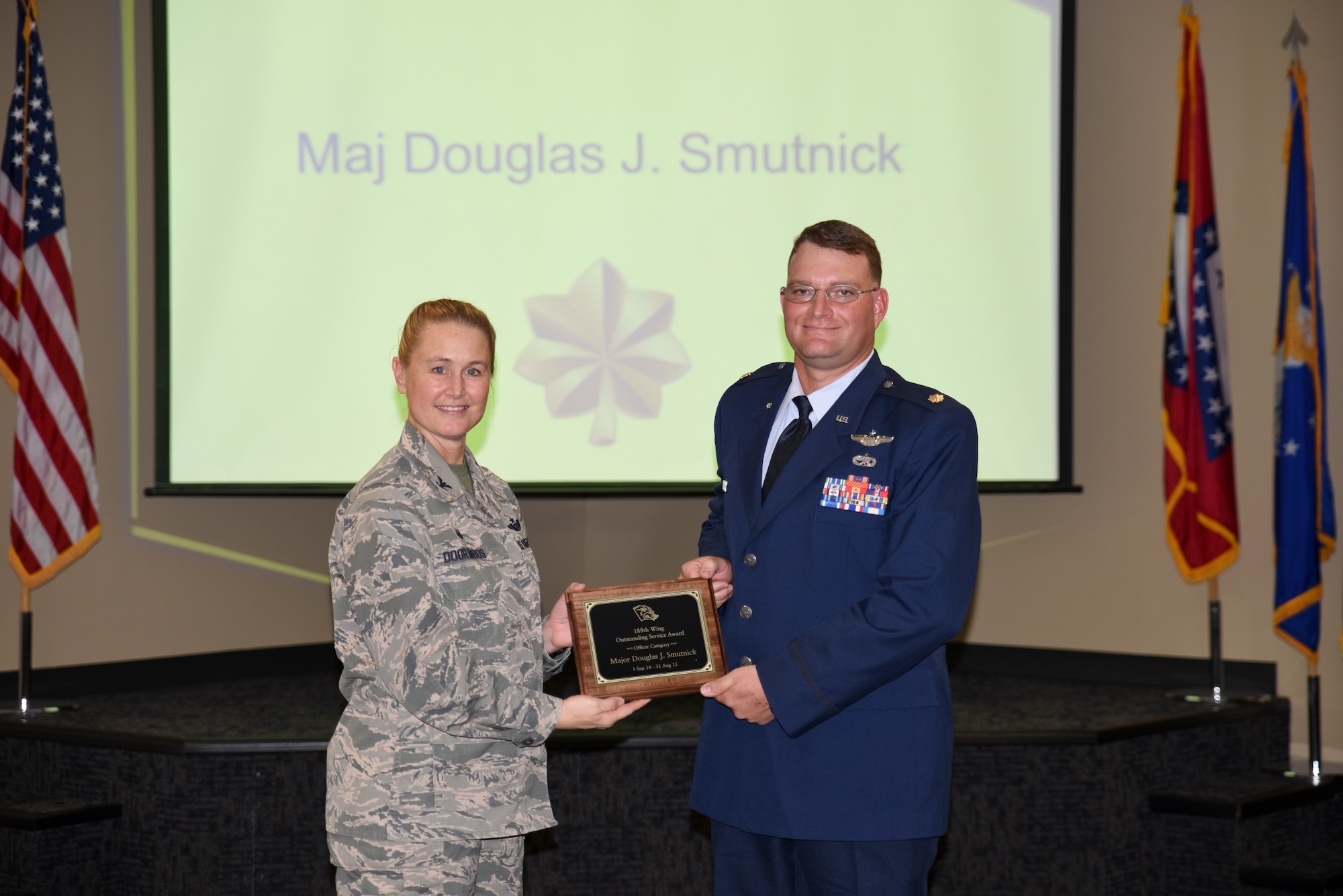 Maj. Douglas Smutnick receives the Outstanding Service Award from Col. Bobbi Doorenbos, 188th Wing commander, for the Field Grade Officer of the Year category. Forty two Outstanding Airmen of the Year nominees were recognized Dec. 5, 2015 during a commander's call for their exceptional service to the wing throughout the last year that distinguished themselves among the best in the 188th. Winners were selected in the Airman, Noncommissioned Officer, Senior NCO, Company Grade Officer and Field Grade Officer categories. (U.S. Air National Guard photo by Capt. Holli Nelson/released)  