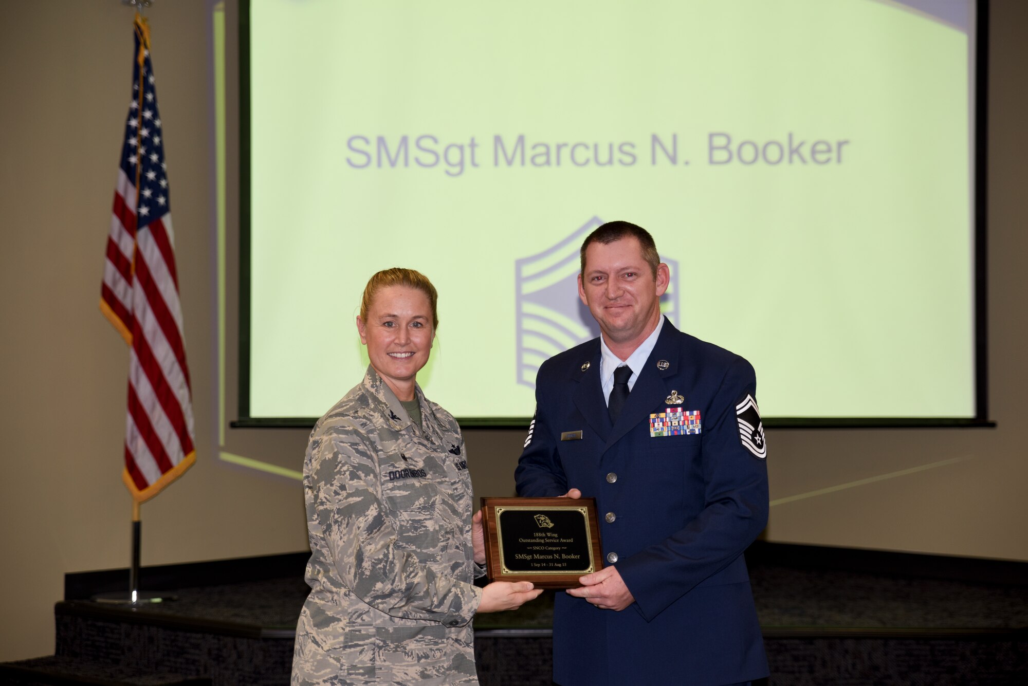 Senior Master Sgt. Marcus Booker receives the Outstanding Service Award from Col. Bobbi Doorenbos, 188th Wing commander, for the Senior Noncommissioned Officer of the Year category. Forty two Outstanding Airmen of the Year nominees were recognized Dec. 5, 2015 during a commander's call for their exceptional service to the wing throughout the last year that distinguished themselves among the best in the 188th. Winners were selected in the Airman, Noncommissioned Officer, Senior NCO, Company Grade Officer and Field Grade Officer categories. (U.S. Air National Guard photo by Capt. Holli Nelson/released)  