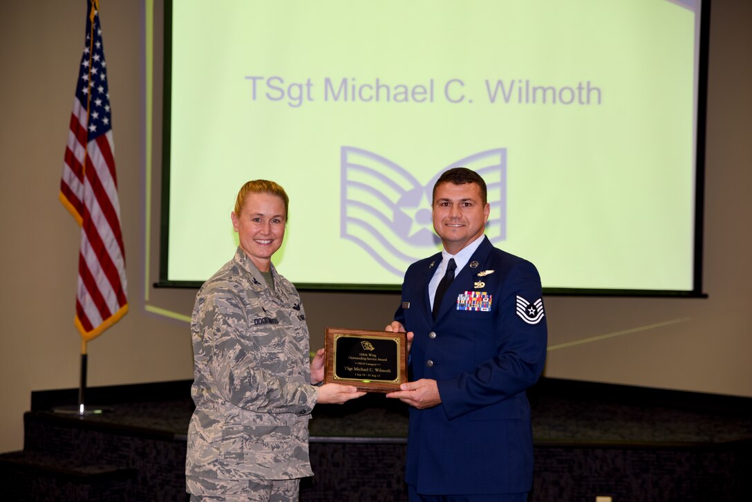 Tech. Sgt. Michael Wilmoth receives the Outstanding Service Award from Col. Bobbi Doorenbos, 188th Wing commander, for the Noncommissioned Officer of the Year category. Forty two Outstanding Airmen of the Year nominees were recognized Dec. 5, 2015 during a commander's call for their exceptional service to the wing throughout the last year that distinguished themselves among the best in the 188th. Winners were selected in the Airman, Noncommissioned Officer, Senior NCO, Company Grade Officer and Field Grade Officer categories. (U.S. Air National Guard photo by Capt. Holli Nelson/released)  