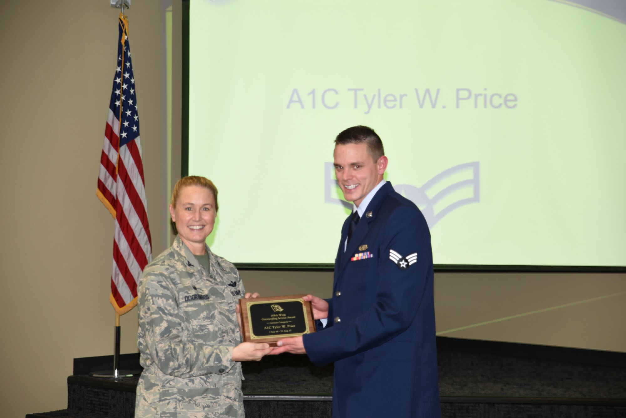 Senior Airman Tyler Price receives the Outstanding Service Award from Col. Bobbi Doorenbos, 188th Wing commander, for the Airman of the Year category. Forty two Outstanding Airmen of the Year nominees were recognized Dec. 5, 2015 during a commander's call for their exceptional service to the wing throughout the last year that distinguished themselves among the best in the 188th. Winners were selected in the Airman, Noncommissioned Officer, Senior NCO, Company Grade Officer and Field Grade Officer categories. (U.S. Air National Guard photo by Capt. Holli Nelson/released)  