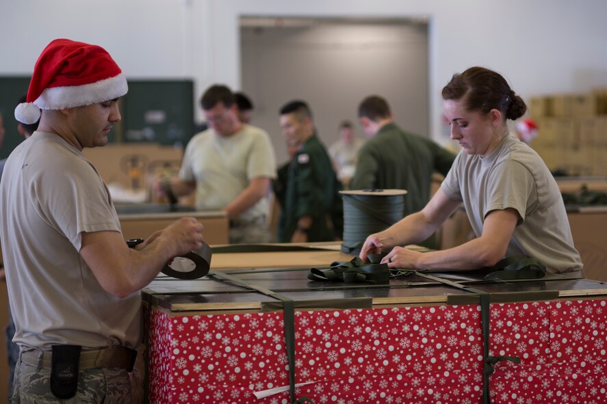 (Left to right) Staff Sgt. Joshua McDonald and Airman 1st Class Cassandra Cobb, 374th Logistics Readiness Squadron combat mobility flight, build a low-cost, low-altitude bundle destined for the island of Fais, during Operation Christmas Drop at Andersen Air Force Base, Guam, Dec. 5, 2015. More than 40,000 pounds of donated goods, including relief supplies will be sent to 56 Micronesian islands during the operation, the longest running Department of Defense humanitarian airdrop mission. (U.S. Air Force photo by Osakabe Yasuo/Released)