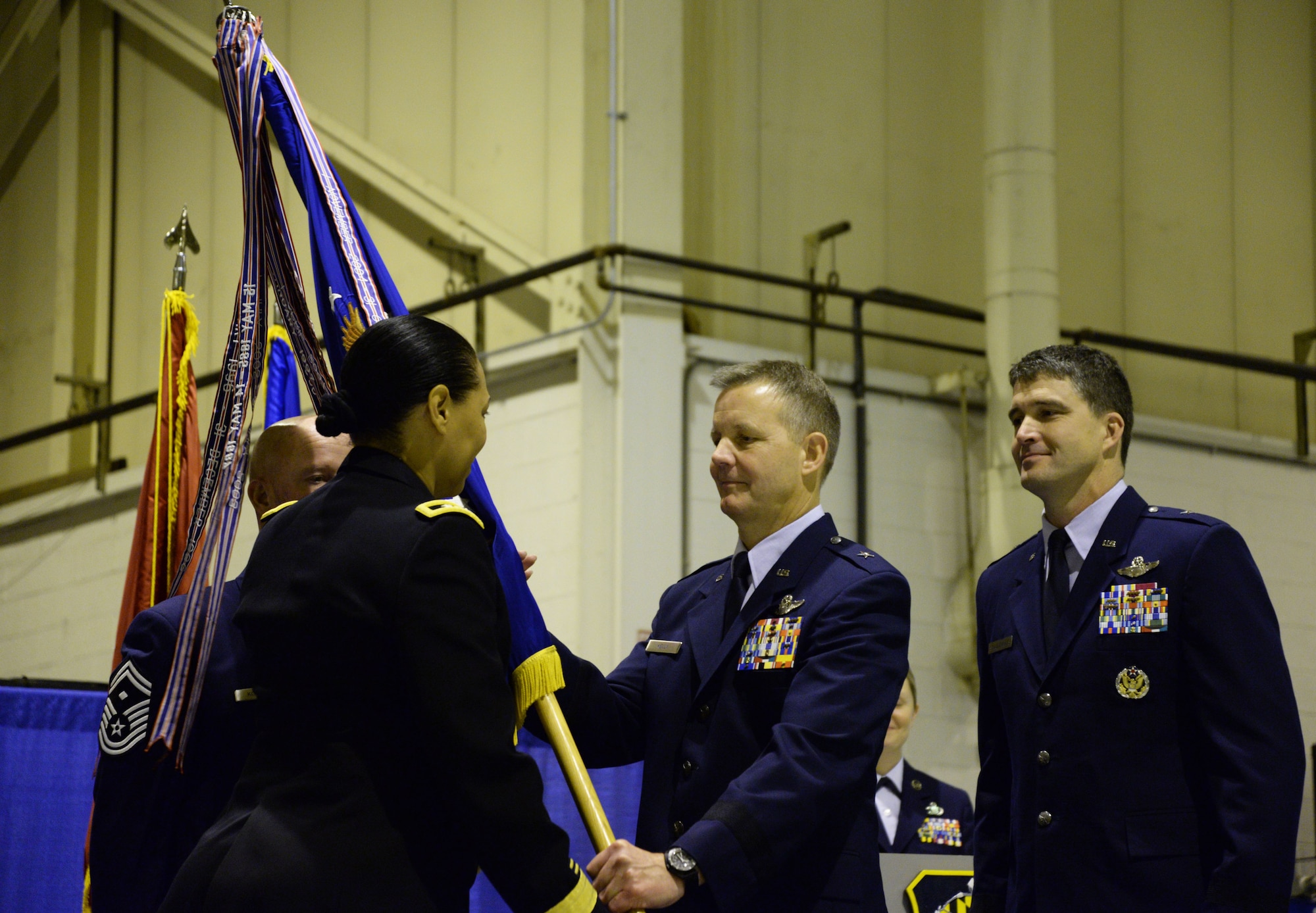 U.S. Air Force Brig. Gen. Scott Kelly, Assistant Adjutant General – Air, passes the 175th Wing guidon to U.S. Army Maj. Gen. Linda Singh, Maryland National Guard Adjutant General, at Warfield Air National Guard Base, Baltimore, Md., during a change of command ceremony December 6, 2015. During the ceremony Brig. Gen. Randolph Staudenraus assumed command of the 175th Wing from Kelly. (U.S. Air National Guard photo by Airman 1st Class Enjoli Saunders/RELEASED)