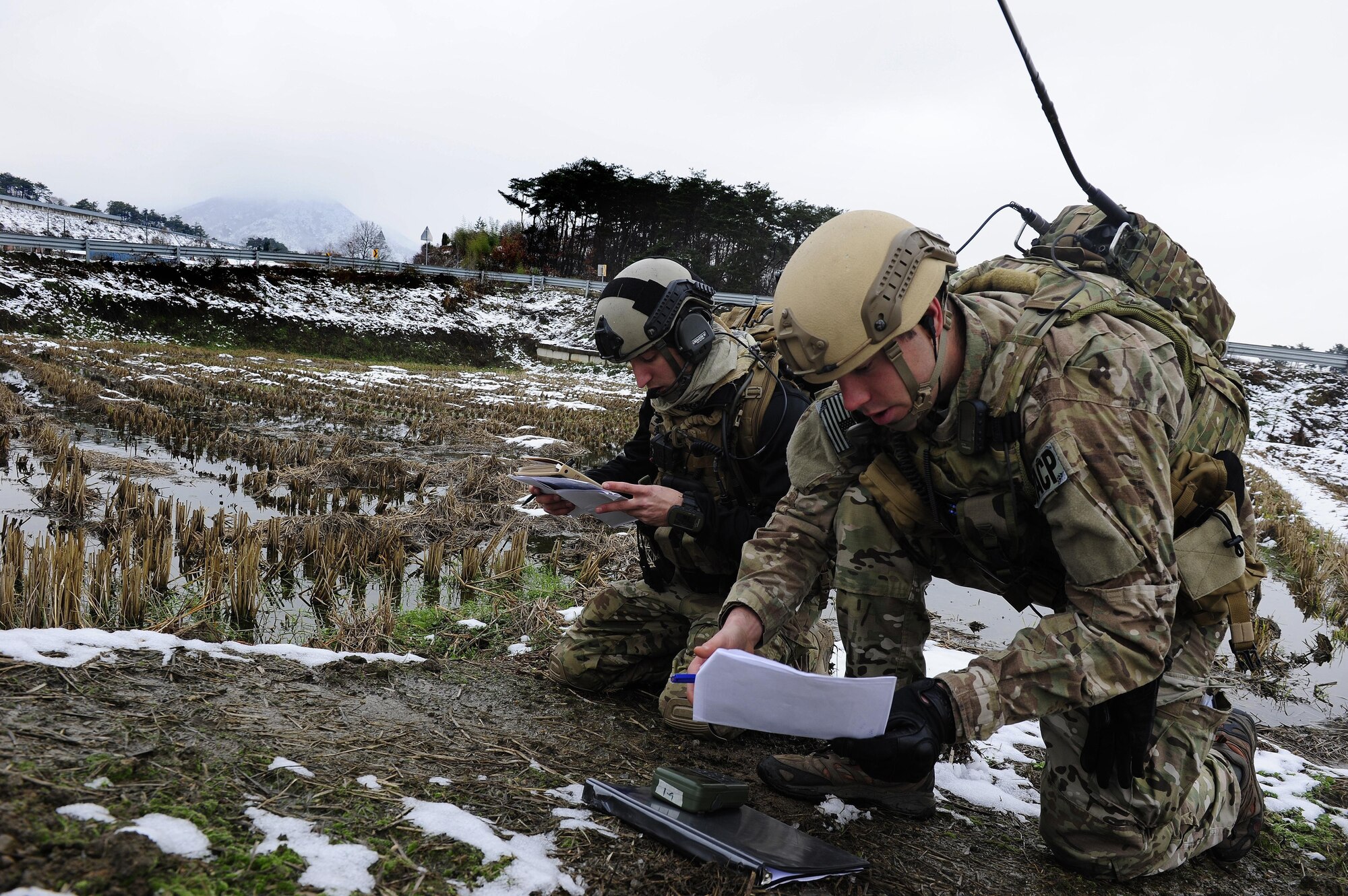 Senior Airman William Irvin, 604th Air Support Operations Squadron joint terminal air controller, and 1st. Lt. Austin Hairfield, 604th ASOS tactical air control party officer in charge, coordinate close air support during Exercise Woody Cloud 16-1, Dec. 4, 2015. Exercise Woody Cloud 16-1 was the first-ever exercise that allowed pilots and JTAC Airmen to train side by side. (U.S. Air Force photo by Staff Sgt. Nick Wilson/Released)