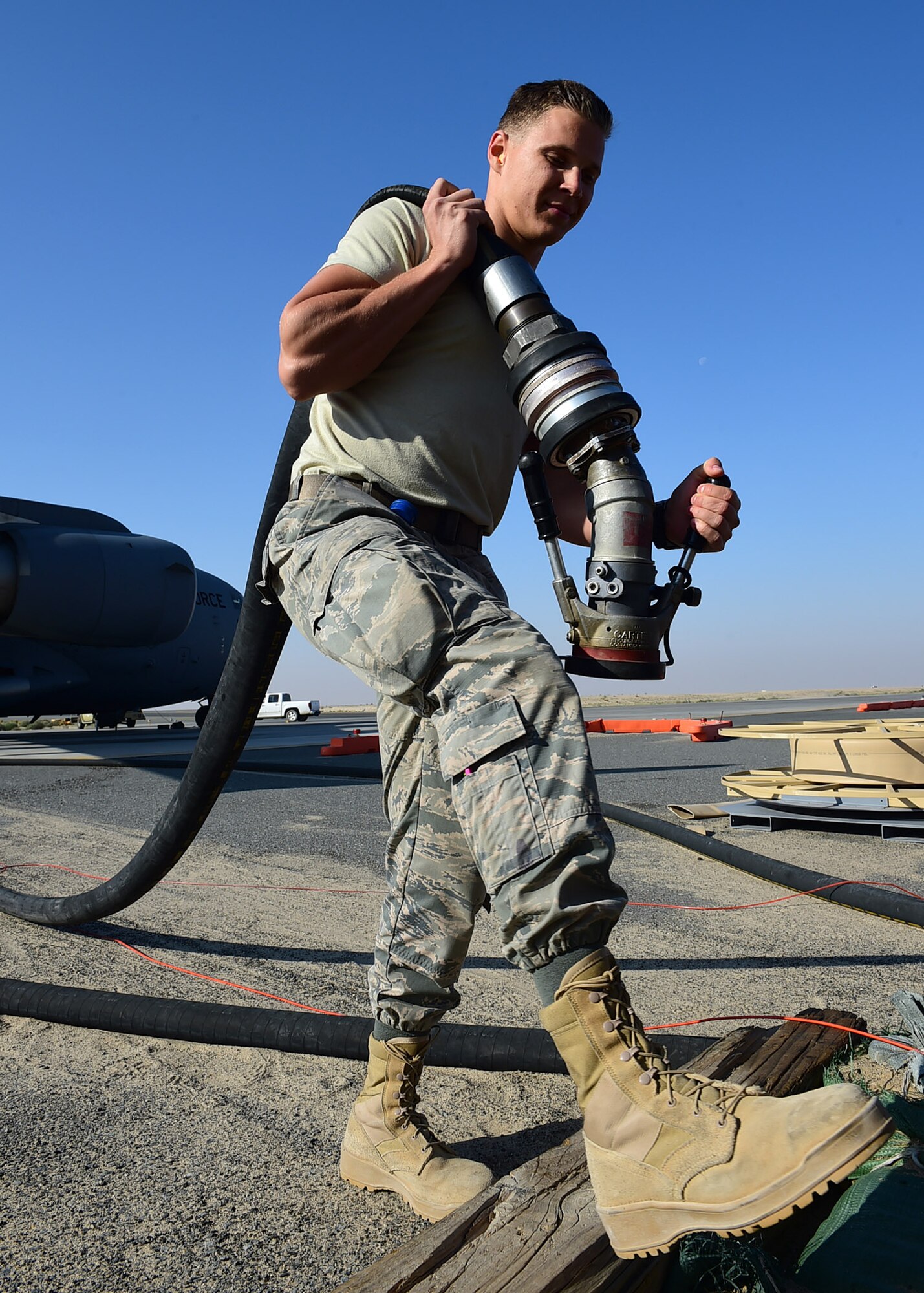 Airman Tyler Normandin, a 386th Expeditionary Logistics Readiness Squadron fuels distribution operator, returns an R-20 multi-servicing platform servicing hose on the flightline at an undisclosed location in Southwest Asia, Dec. 1, 2015. The platform is a stationary fuel servicing system capable of providing thousands of gallons of fuel to larger aircraft such as the C-17 and C-130 with ease. (U.S. Air Force photo by Staff Sgt. Jerilyn Quintanilla)