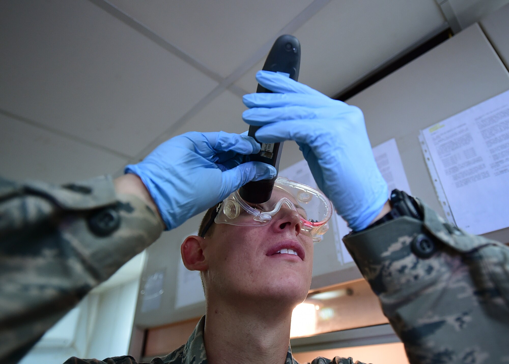 Senior Airman Nickolauss Guier, a 386th Expeditionary Logistics Readiness Squadron fuels systems journeyman, looks through a refractometer while conducting a Fuel System Icing Inhibitor test at an undisclosed location in Southwest Asia, Dec. 1, 2015. The POL flight is responsible for providing fuel to all aircraft, and ground equipment for U.S. and coalition forces on base in support of Operation INHERENT RESOLVE. (U.S. Air Force photo by Staff Sgt. Jerilyn Quintanilla)