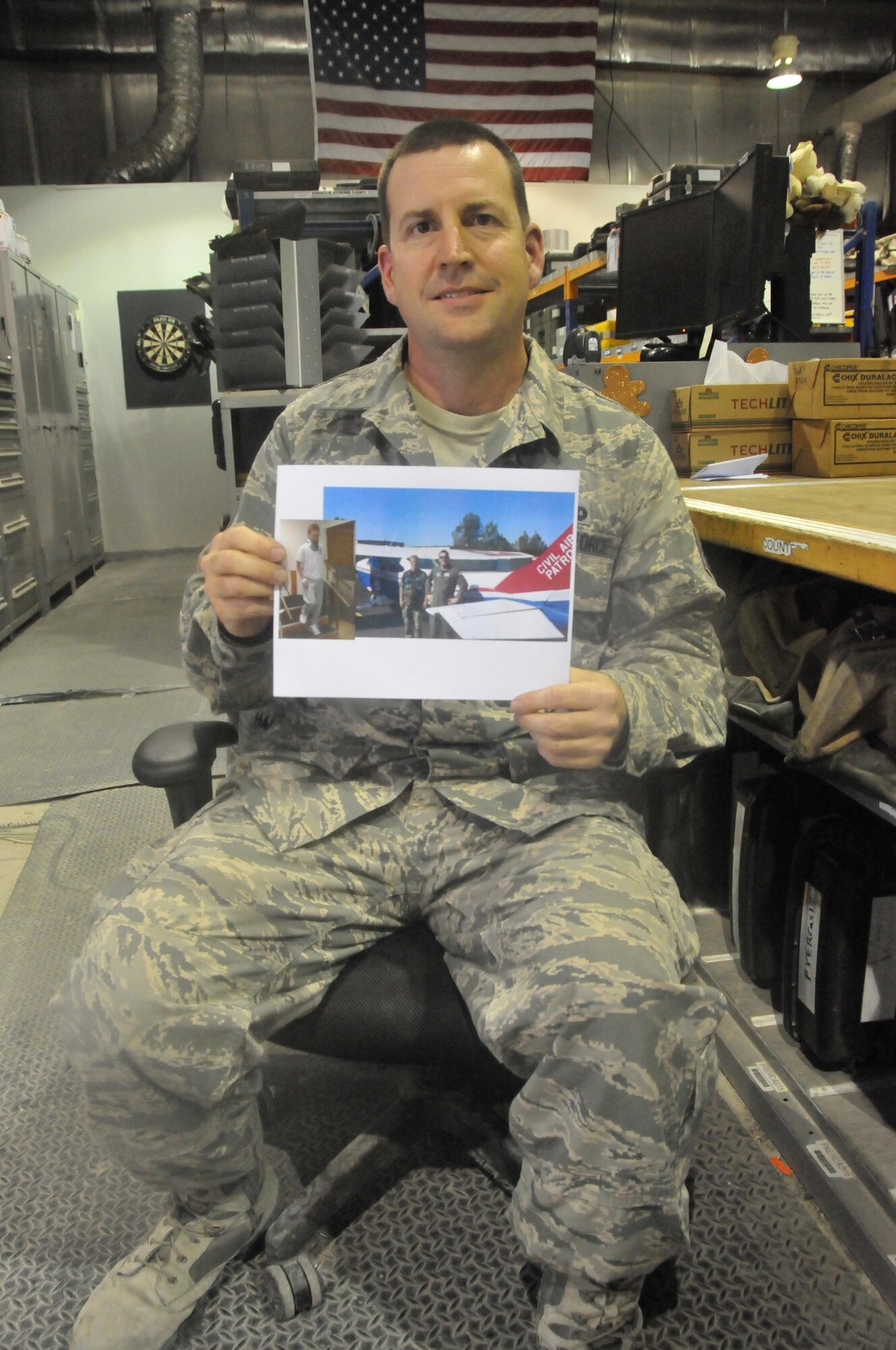 Staff Sgt. Daniel Stein, 8th Expeditionary Air Mobility Squadron crew chief, holds a picture of his son, Gregory. In November, Gregory was in an all-terrain vehicle accident and fractured his C-1 vertebrae. The 8th EAMS, Qatari Emiri Air Force and the Boeing Company put together a care package for Gregory. The care package consisted of mementos from 8th EAMS members, a QAEF C-17 replica and a Qatar flag. . (U.S Air Force photo courtesy of Staff Sgt. Stein/Released)
