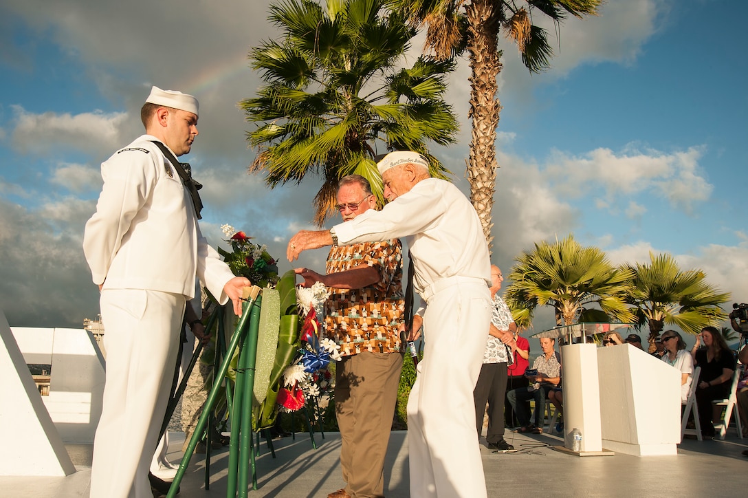 Delton "Wally" Walling, Pearl Harbor survivor, accepts a ceremonial wreath to present to the entombed crew of the USS Utah during a memorial sunset tribute at Ford Island, Joint Base Pearl Harbor-Hickam, Hawaii, Dec. 6, 2015. U.S. Navy photo by Petty Officer 2nd Class Gabrielle Joyner