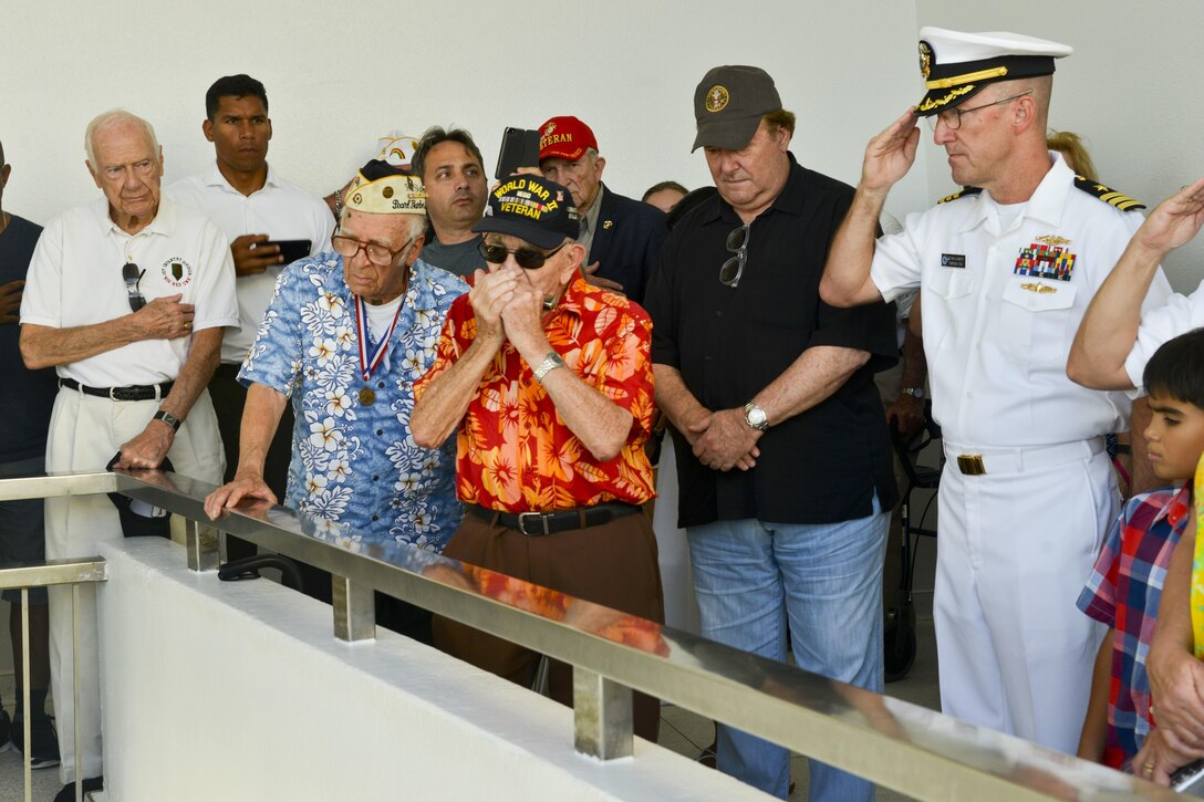 Peter B. Dupre', a World War II Veteran, plays taps on his harmonica during a floral tribute aboard the USS Arizona Memorial on Joint Base Pearl Harbor-Hickam, Hawaii, Dec. 5, 2015. Dupre' was attending a harbor tour in observance of the 74th anniversary of the Dec. 7, 1941 attack. U.S. Navy photo by Petty Officer 2nd Class Tamara Vaughn