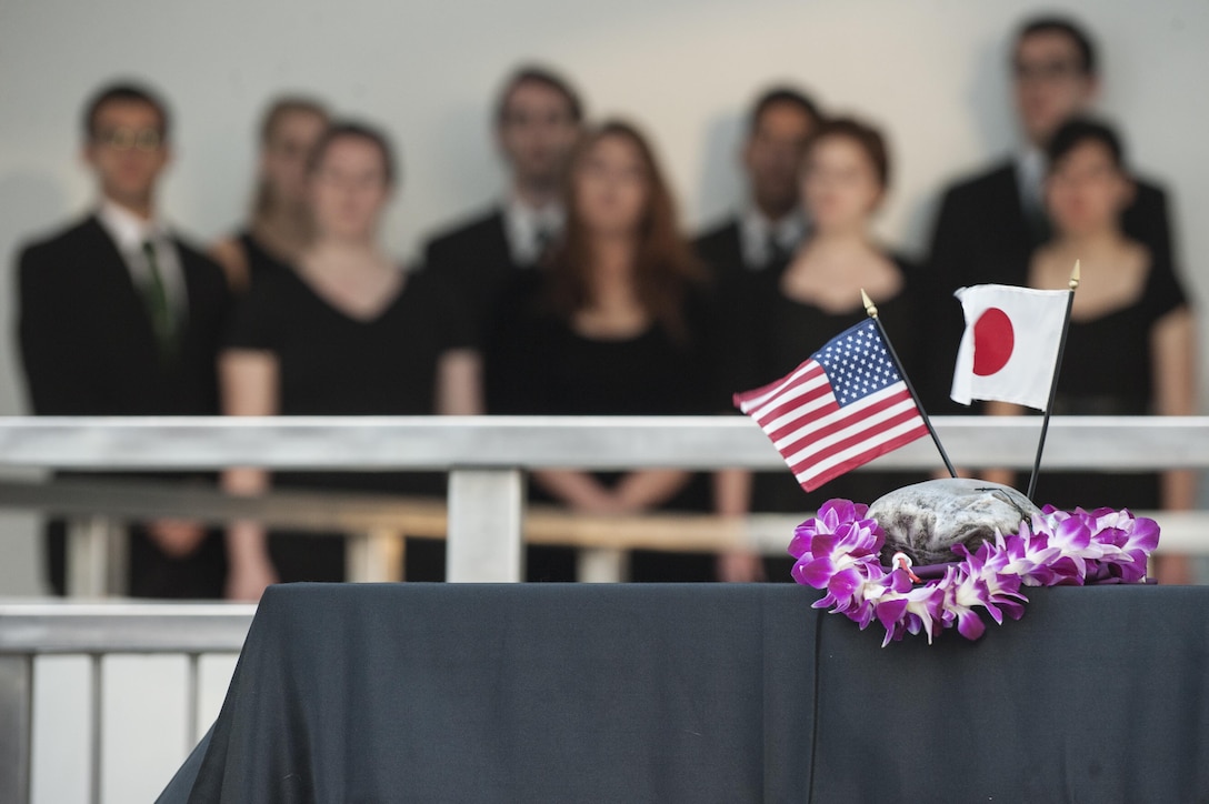 An audience consisting of veterans and spectators from the United States and Japan attend a Blackened Canteen ceremony as part of the 74th anniversary of Pearl Harbor Day Commemoration Anniversary at the USS Arizona Memorial, Hawaii, Dec. 6, 2015. The Blackened Canteen ceremony is a way for Americans and Japanese veterans and observers to extend a hand of continued friendship, peace and reconciliation by pouring bourbon whiskey as an offering to the fallen in the hallowed waters of Pearl Harbor. U.S. Air Force photo by Staff Sgt. Christopher Hubenthal