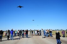 Spouses of Airmen from the 315th Airlift Wing, Joint Base Charleston, SC, look to the sky as three C-17 Globemaster III's fly overhead in formation at North Auxilary Airfield, North, SC. This event was part of a spouse flight allowing spouses to experience an operational aircraft executing training requirements of the flight crews. (U.S. Air Force photo by Staff Sgt. Bobby Pilch)