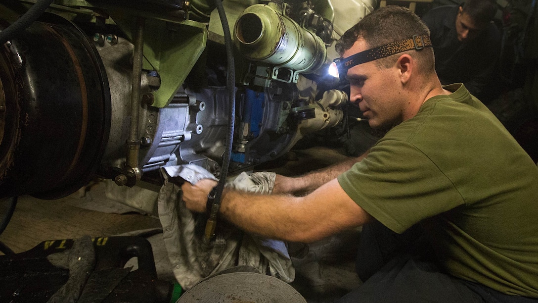 Sgt. Kevin S. Kuykendall, a light armored vehicle crewman with Light Armored Reconnaissance Company, Battalion Landing Team 2/6, 26th Marine Expeditionary Unit, cleans an LAV engine aboard the amphibious assault ship USS Kearsarge Dec. 4, 2015. Crewman with the company assisted repairmen that were servicing an LAV engine with an oil leak. The 26th MEU is embarked on the Kearsarge Amphibious Ready Group and is deployed to maintain regional security in the U.S. 5th Fleet area of operations. 