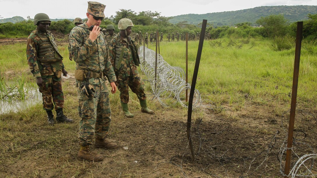 U.S. Marine Staff Sgt. Malachi McPherson, an explosive ordnance disposal technician with Special-Purpose Marine Air-Ground Task Force Crisis Response-Africa and Uganda People’s Defense Force soldiers observe the efficiency of their breach on a razor-wire obstacle during a breaching exercise at Camp Singo, Uganda, Dec. 1, 2015. The Marines and UPDF improved breaching capabilities as they prepare for their African Union Mission in Somalia.