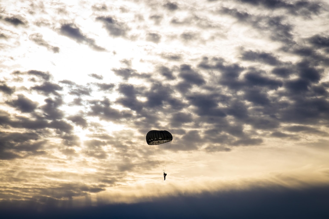 A paratrooper descends at Nijmegen drop zone for the 18th Annual Randy Oler Memorial Operation Toy Drop, hosted by U.S. Army Civil Affairs & Psychological Operations Command, Airborne, on Fort Bragg, N.C., Dec. 3, 2015. Operation Toy Drop is the world’s largest combined airborne operation and collective training exercise allowing soldiers the opportunity to help children in need receive toys for the holidays. U.S. Army photo by Master Sgt. Mark Burrell