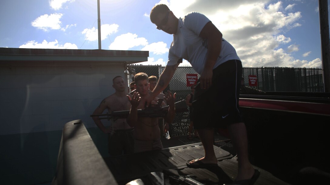 Seaman Nicholas Conklin, a corpsman with 3rd Regiment, and a Sanger, Texas, native, hands out gear to students in the Marine Corps Instructor Course of Water Survival at the base pool aboard Marine Corps Base Hawaii, Dec. 1, 2015. MCICWS is a course for noncommissioned officers and higher to become water survival instructors, whose purpose is to make sure Marines are safe during basic swim qualification.