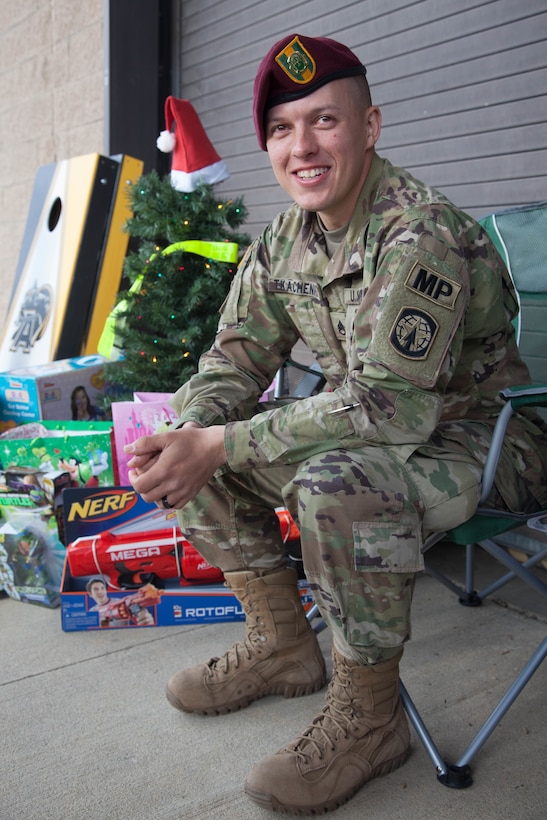 Army Staff Sgt. Micheal Tkachenko waits first in line to donate his toy in exchange for a chance to earn jump wings from one of seven partner nations participating in the 18th Annual Randy Oler Memorial Operation Toy Drop, hosted by U.S. Army Civil Affairs & Psychological Operations Command, Airborne, on Fort Bragg, N.C., Dec. 4, 2015. Tkachenko is assigned to the 65th Military Police Company. U.S. Army photo by Spc. Joshua Wooten
