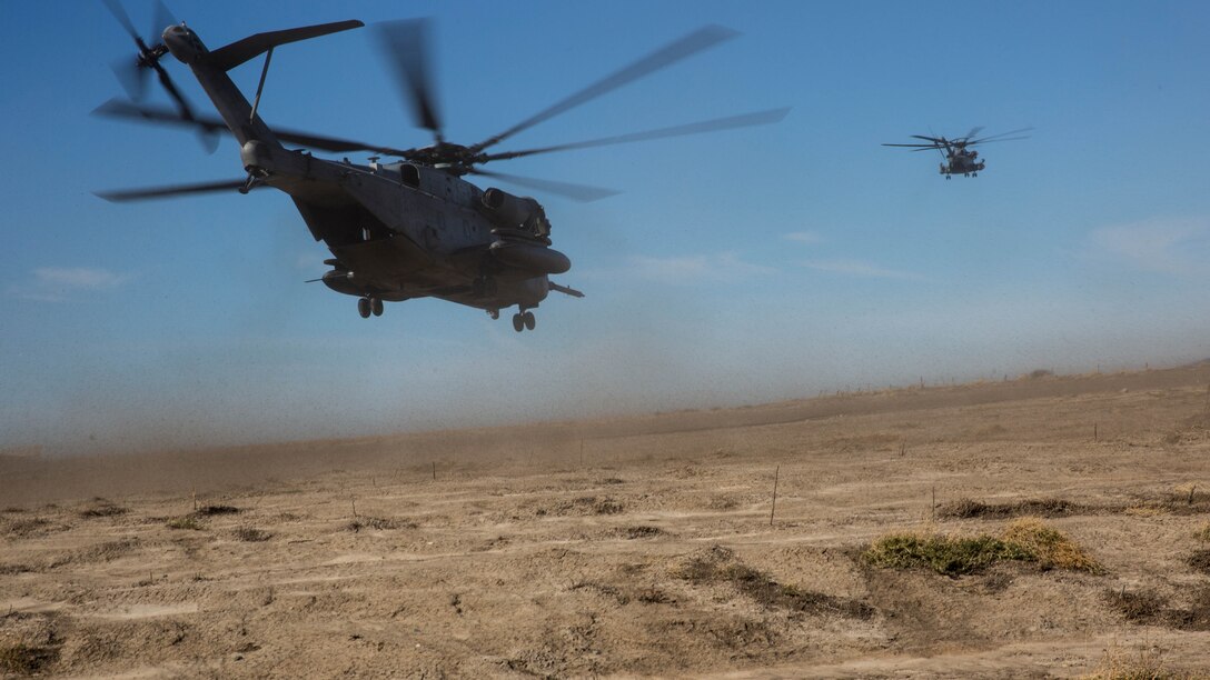 Two CH-53E Super Stallions take off during section Confined Area Landings board Marine Corps Base Camp Pendleton, Calif., Dec. 2, 2015. Marines with HMH-361 conducted section Confined Area Landings and Field Carrier Landing Practices to fulfill training requirements for landing aboard a Navy ship. 