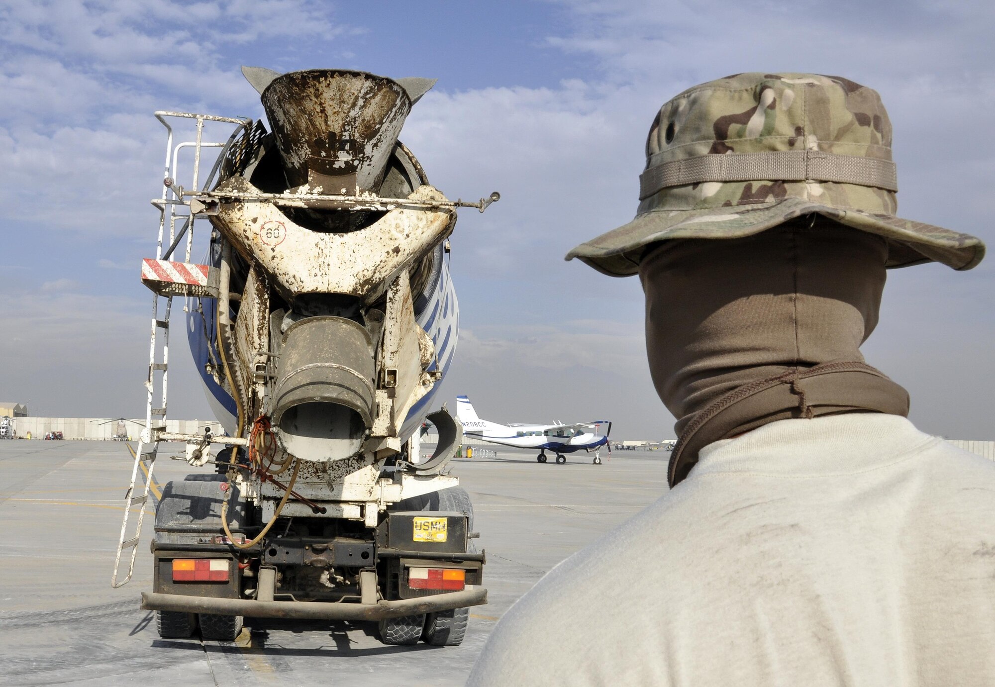 Staff Sgt. Richard Bonham, 455th Expeditionary Civil Engineer Squadron, waits for a concrete truck to get into position to repair a section of the flightline at Bagram Airfield, Afghanistan, Dec. 7, 2015. Airfield integrity concerns are reviewed twice a month by Airfield Management and 455th ECES. Once repairs are completed, these areas of the flightline should not require maintenance for up to 10 years.  (U.S. Air Force photo by Tech. Sgt. Nicholas Rau/Released)