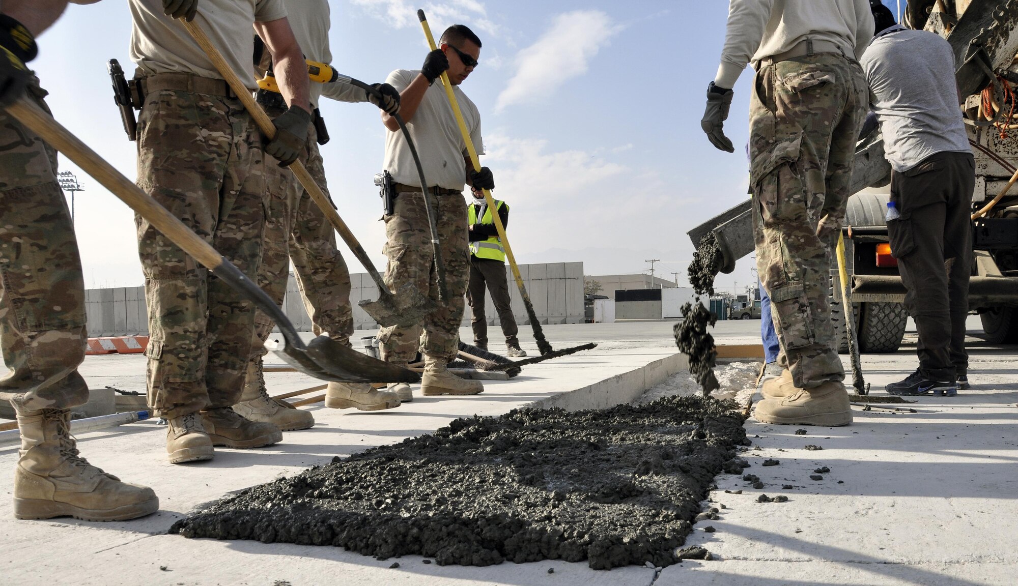 Airmen from the 455th Expeditionary Civil Engineer Squadron level out cement to repair a section of the flightline at Bagram Airfield, Afghanistan, Dec. 7, 2015. Airfield integrity concerns are reviewed twice a month by Airfield Management and 455th ECES. Once repairs are completed, these areas of the flightline should not require maintenance for up to 10 years.  (U.S. Air Force photo by Tech. Sgt. Nicholas Rau/Released)
