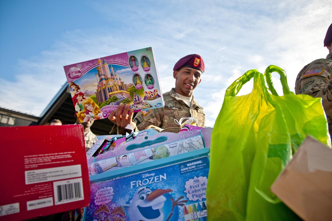 A paratrooper puts a toy he's donating into the collection box as he prepares for the 18th annual Randy Oler Memorial Operation Toy Drop on Fort Bragg, N.C., Dec. 3, 2015. U.S. Army photo by Staff Sgt. Timothy Koster