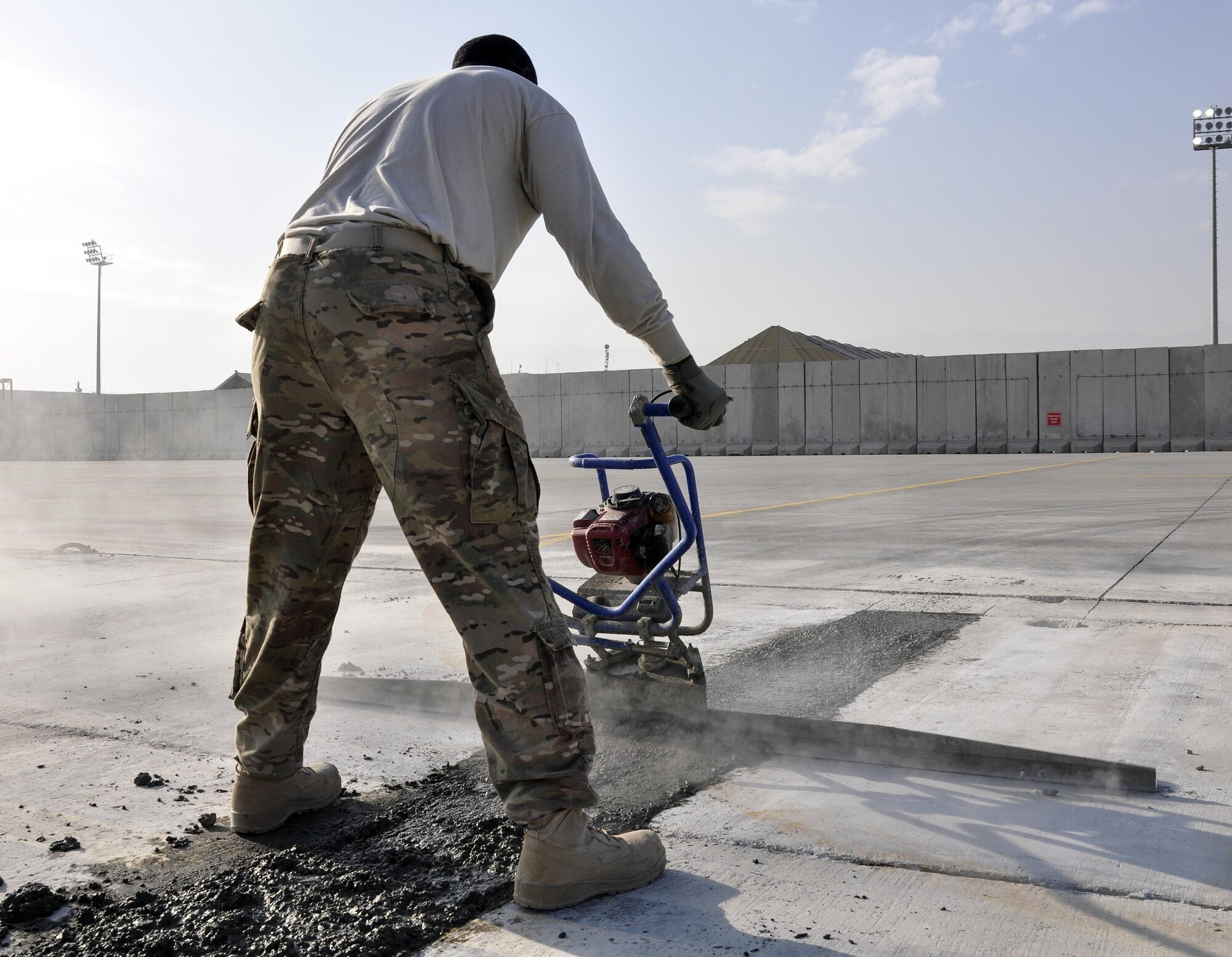 Staff Sgt. Richard Bonham, 455th Expeditionary Civil Engineer Squadron, operates a machine that presses down concrete in order to repair a section of the flightline at Bagram Airfield, Afghanistan, Dec. 7, 2015. Airfield integrity concerns are reviewed twice a month by Airfield Management and 455th ECES. Once repairs are completed, these areas of the flightline should not require maintenance for up to 10 years.  (U.S. Air Force photo by Tech. Sgt. Nicholas Rau/Released)