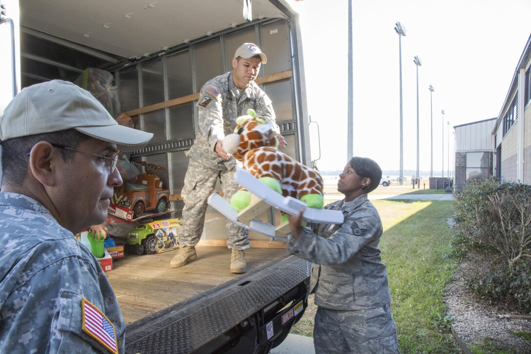Service members load a truck full of toys donated by Army paratroopers who entered a raffle to obtain partner-nation jump wings for the 18th Annual Randy Oler Memorial Operation Toy Drop, hosted by U.S. Army Civil Affairs & Psychological Operations Command, Airborne, on Fort Bragg, N.C., Dec. 4, 2015. U.S. Army photo Spc. Tracy McKithern