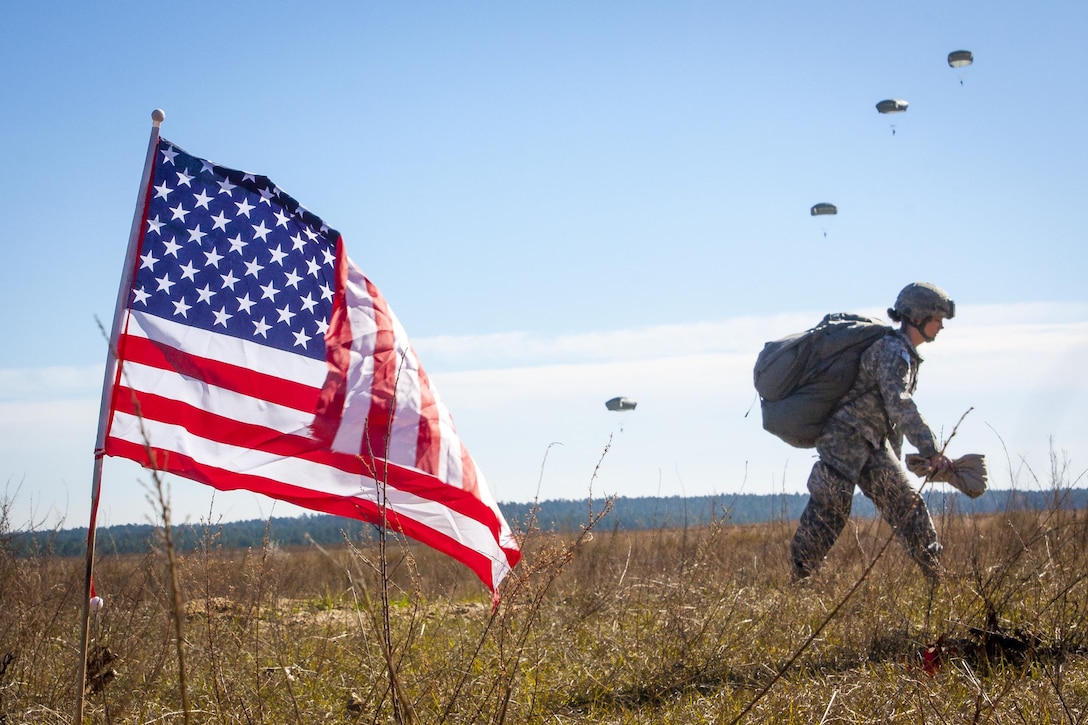 A paratrooper returns after completing her jump in participation for the 18th Annual Randy Oler Memorial Operation Toy Drop, hosted by U.S. Army Civil Affairs & Psychological Operations Command, Airborne, on Sicily drop zone at Fort Bragg, N.C., Dec. 4, 2015. The paratrooper is assigned to the 82nd Airborne Division. U.S. Army photo by Sgt. Destiny Mann