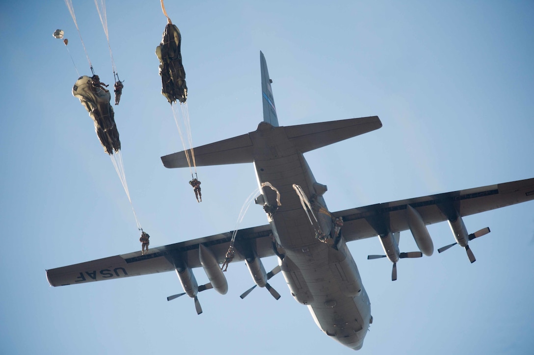 Army paratroopers exit from a C-130 Hercules aircraft during an airborne operation for the 18th Annual Randy Oler Memorial Operation Toy Drop over Sicily drop zone on Fort Bragg, N.C., Dec. 4, 2015. The paratroopers are assigned to the d Airborne Division. U.S. Army photo by Staff Sgt. Alex Manne