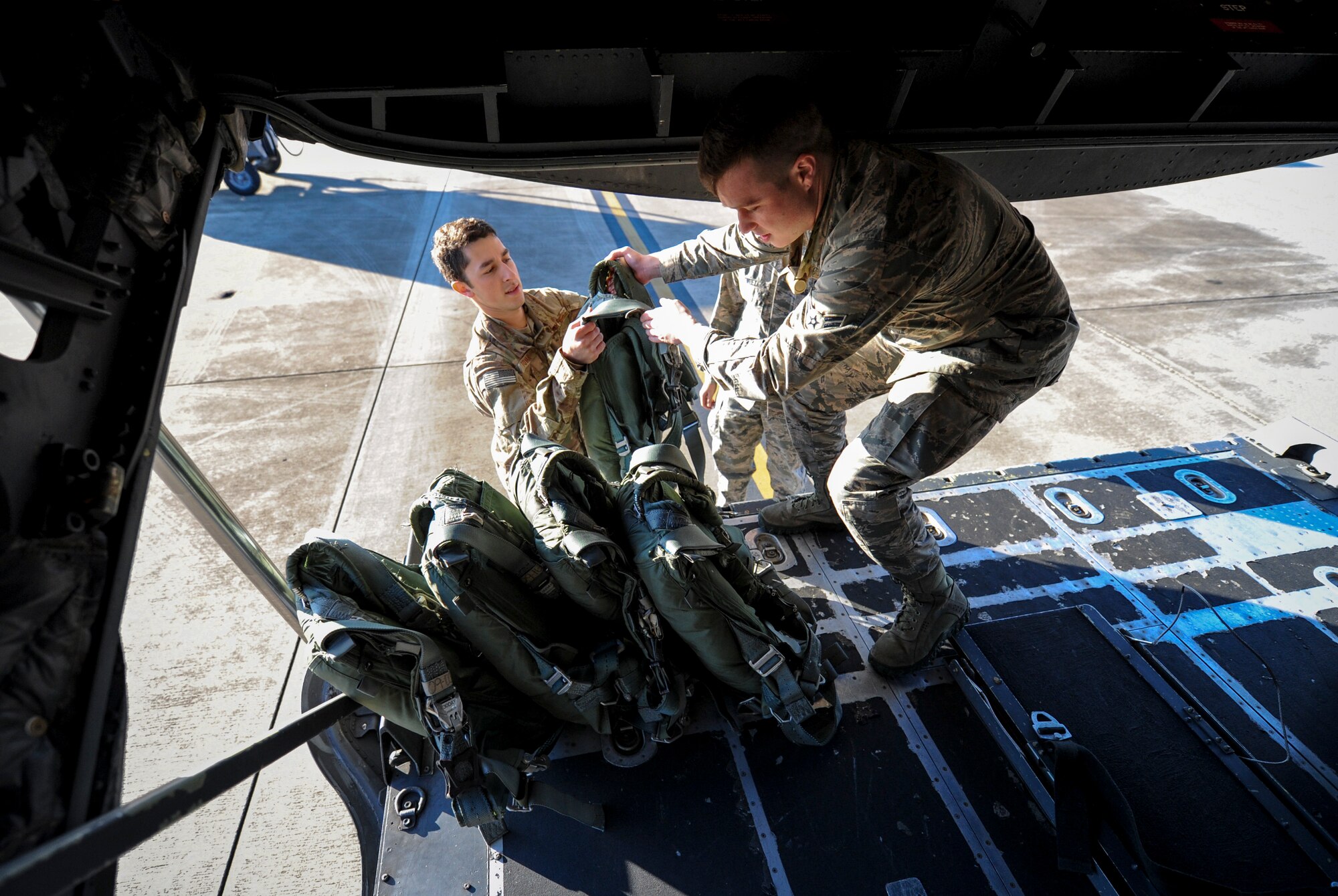 Airmen with the 4th Special Operations Squadron aircrew flight equipment shop swap out BA-22 parachutes during a pre-flight inspection at Hurlburt Field, Fla., Dec. 4, 2015. During pre-flight inspections, equipment is checked to ensure operability for each flight. (U.S. Air Force photo by Senior Airman Krystal M. Garrett)